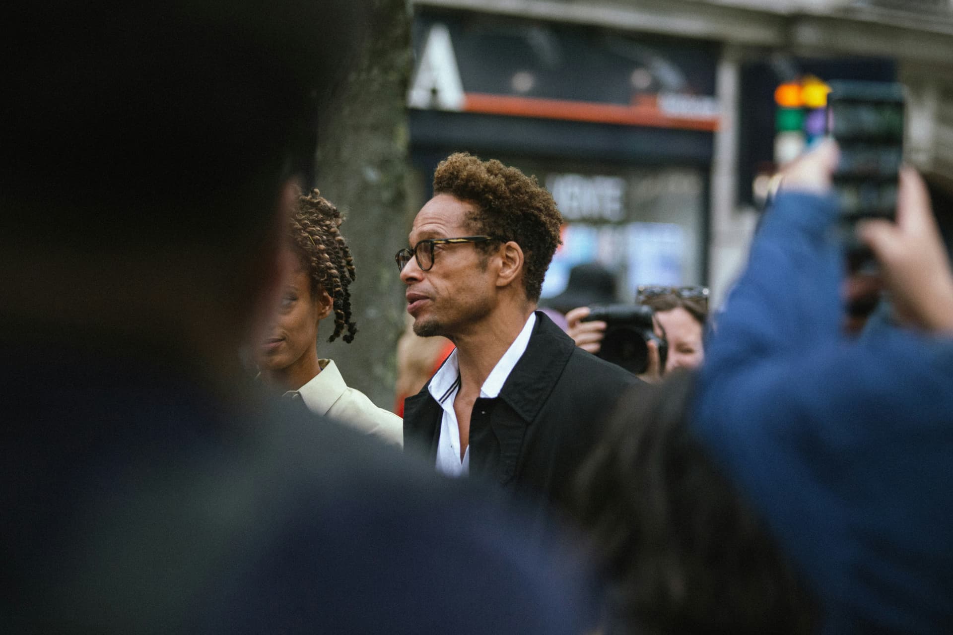 Street-style photographers and guests outside a fashion venue