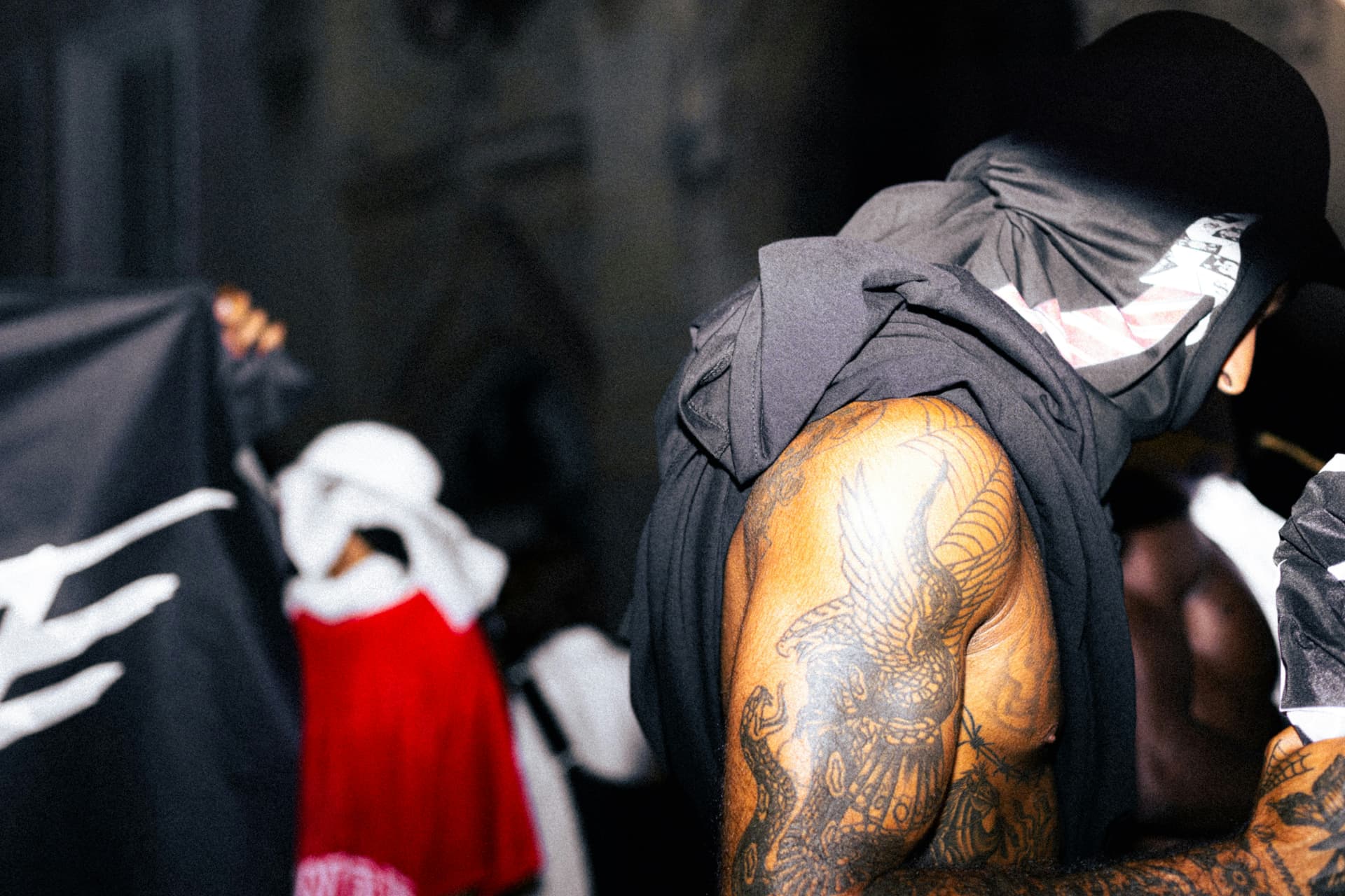A figure in a hoodie in a contemporary urban environment