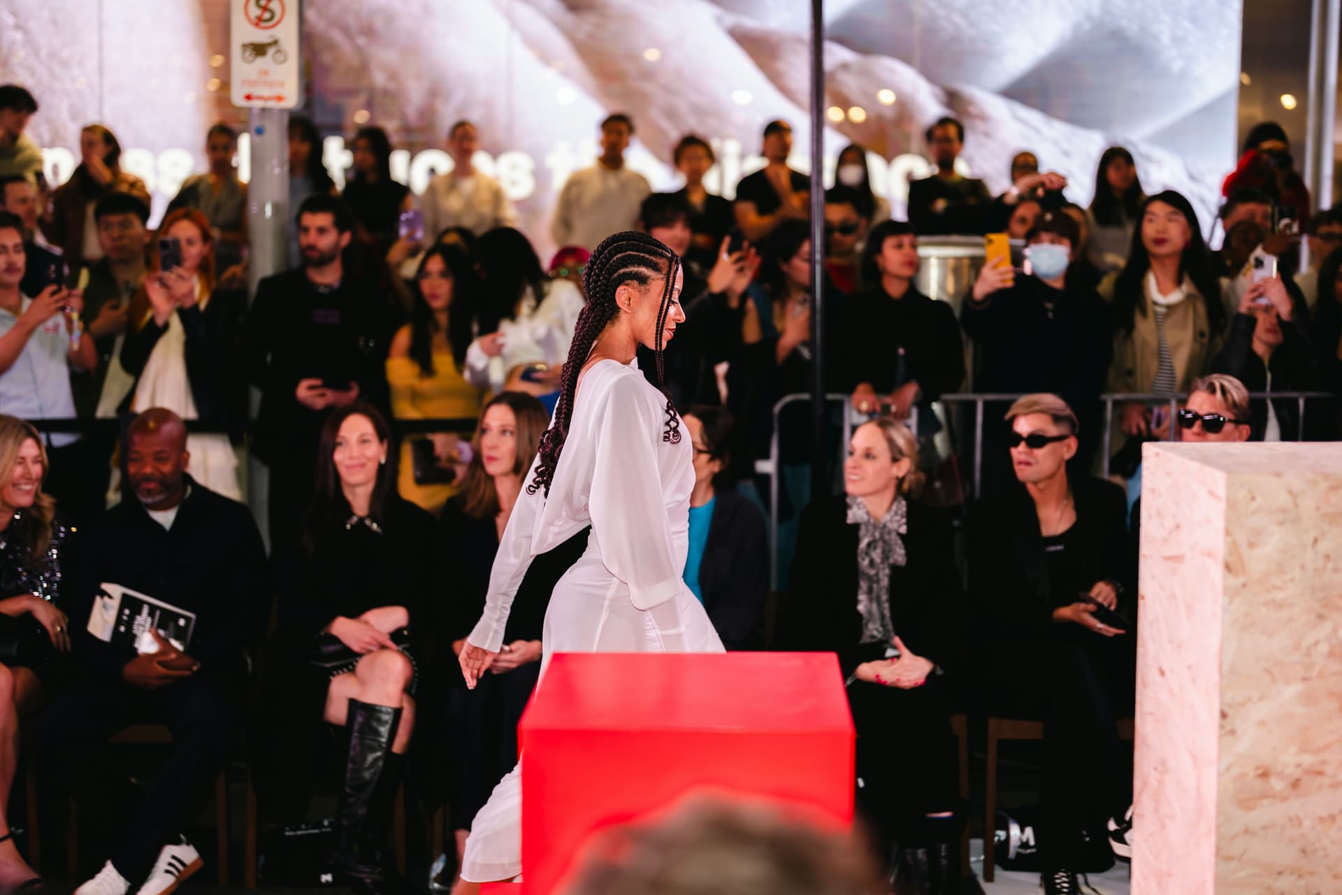 Photographers and production staff working with garments away from the runway