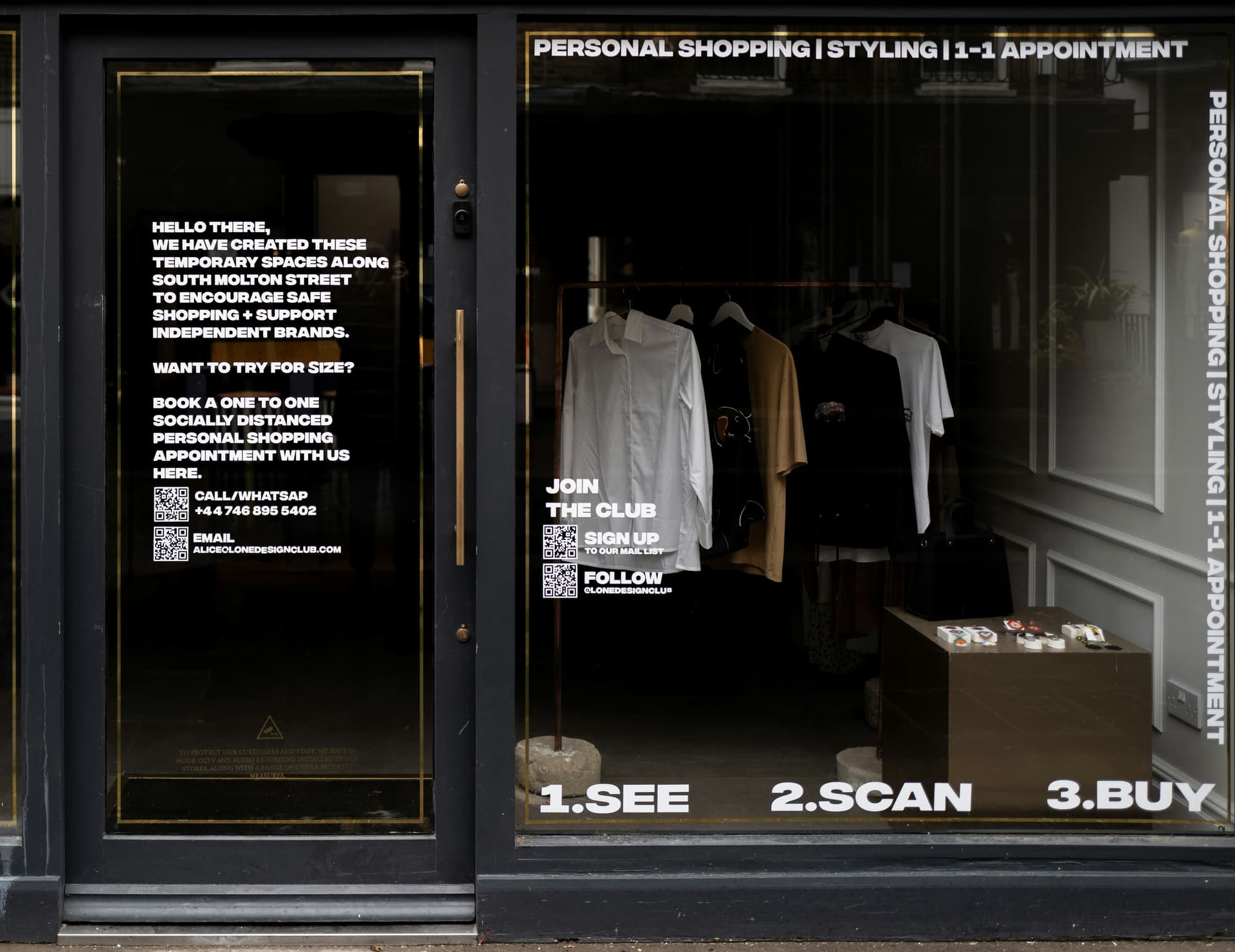 A boutique storefront window with QR codes and instructions for digital shopping
