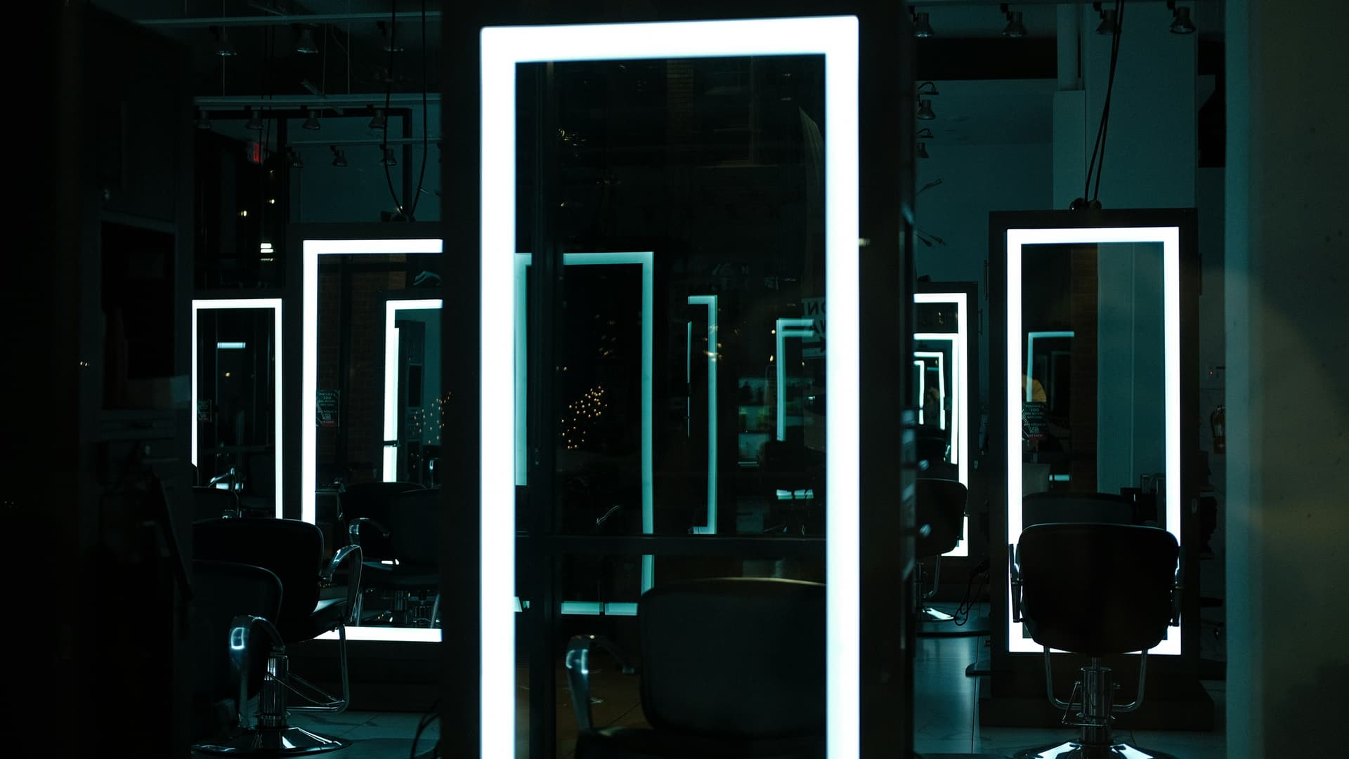 A beauty salon with LED-framed mirrors and chairs