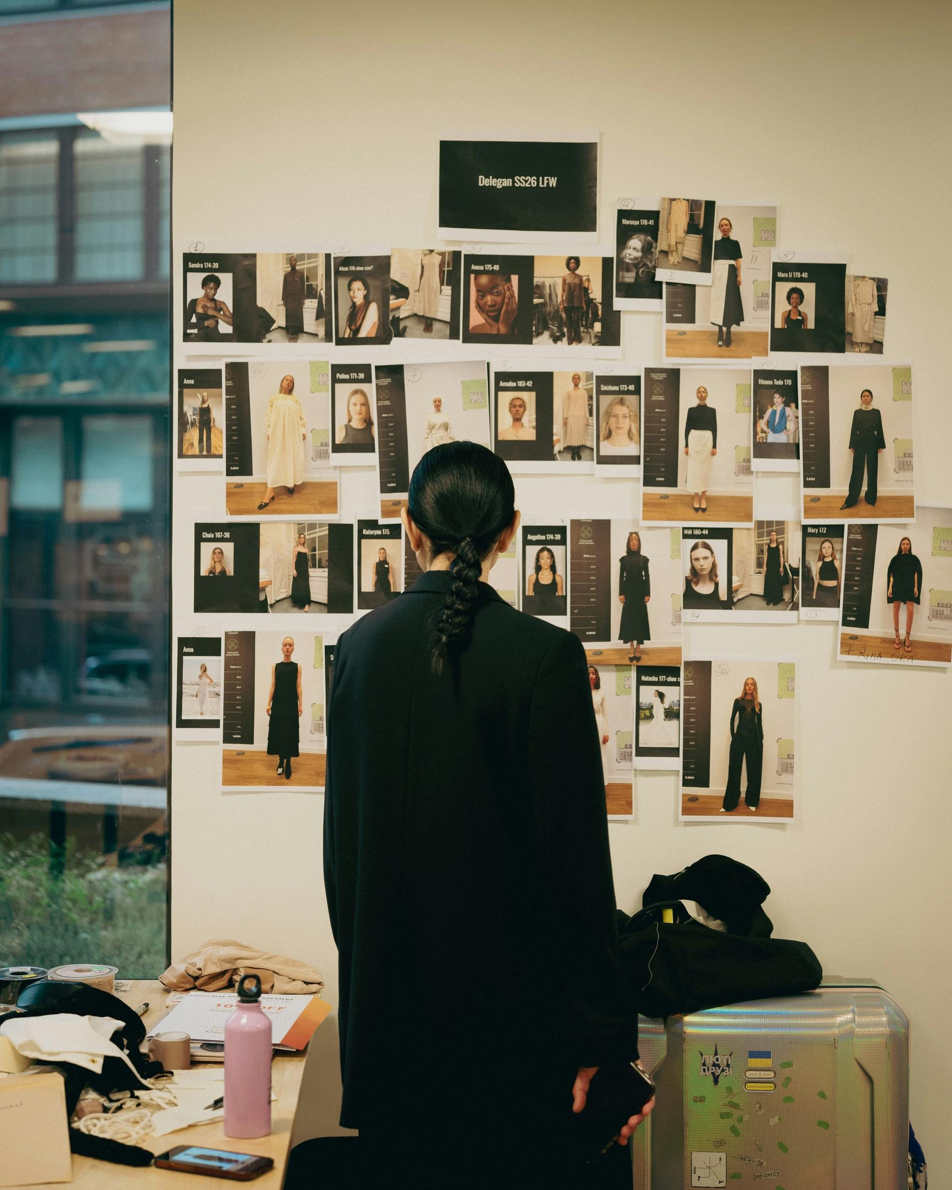 A casting wall with model cards and look references for London Fashion Week
